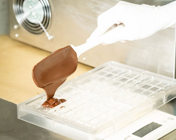 チョコレートを型に流し入れるnicaoの手作業
